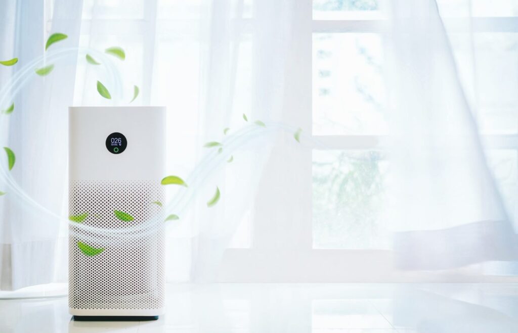 Picture of an air purifier in a white background with airy curtains.